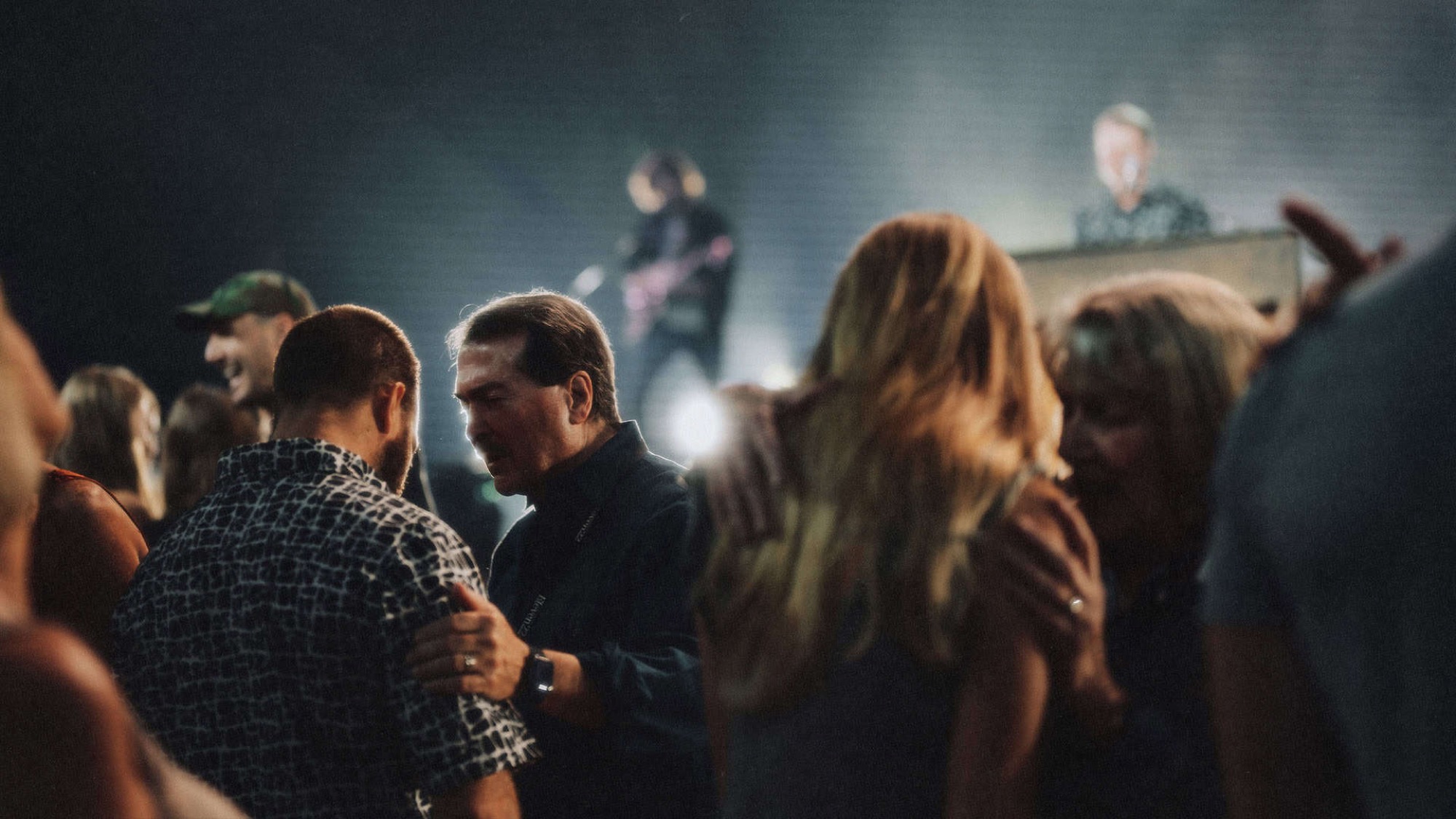 A Care Team member praying with a man during a worship service